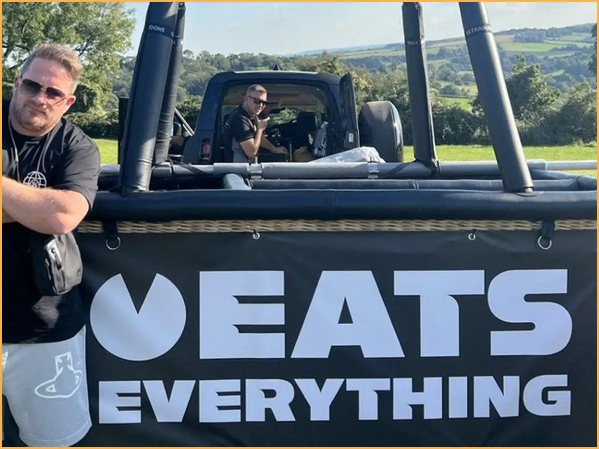 Loud Hire crew in a hot air balloon basket with an Eats Everything banner