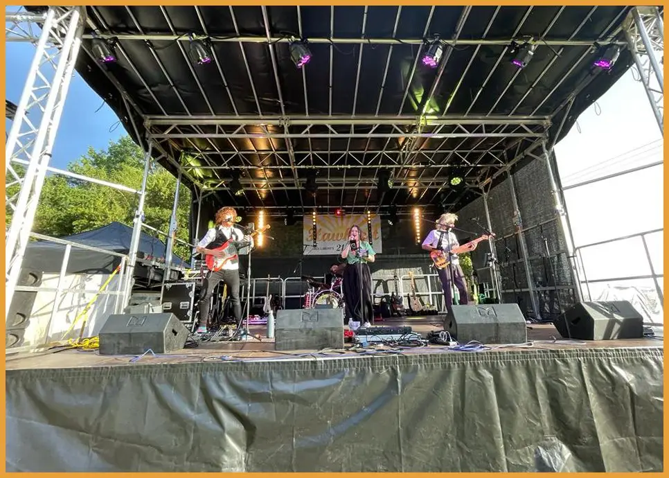 Band performing on the stage under truss lighting