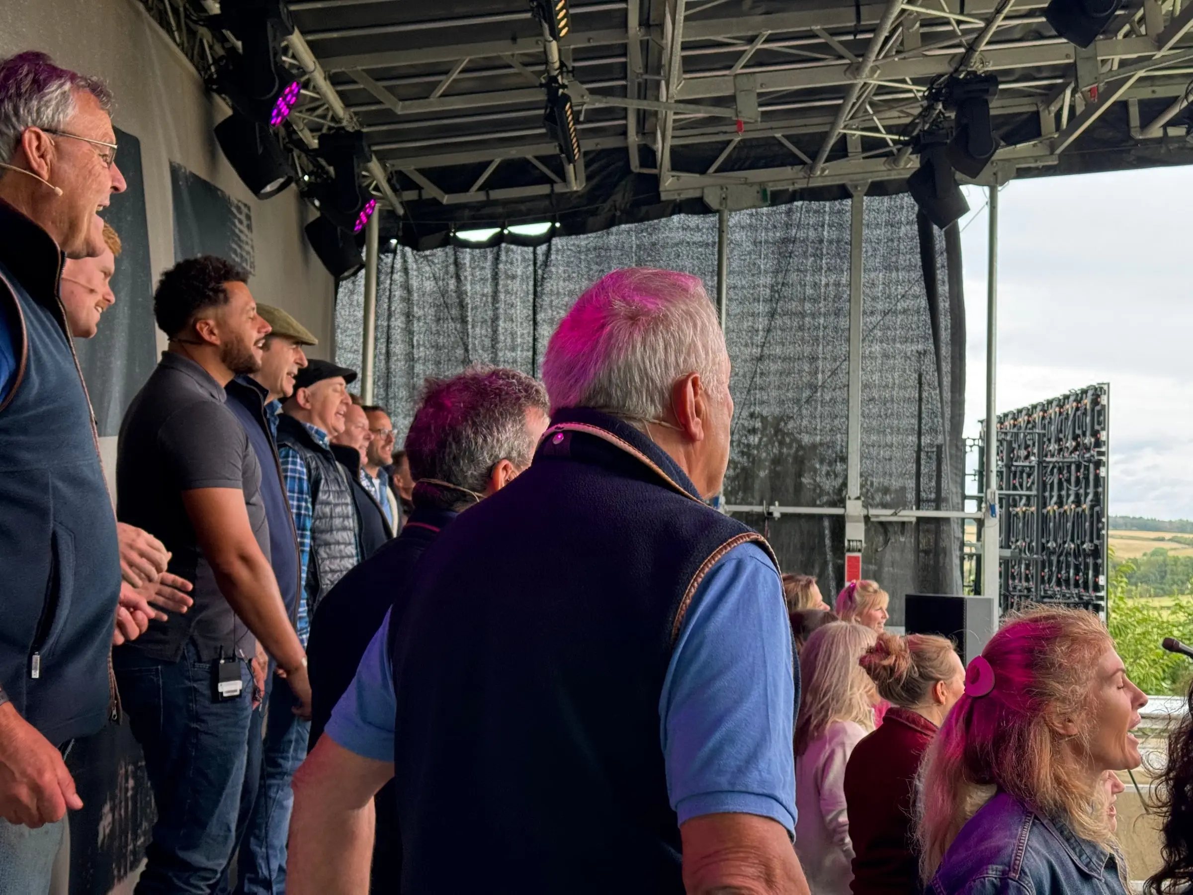 Side-stage view of the Hawkstone Farmers Choir wearing headset microphones