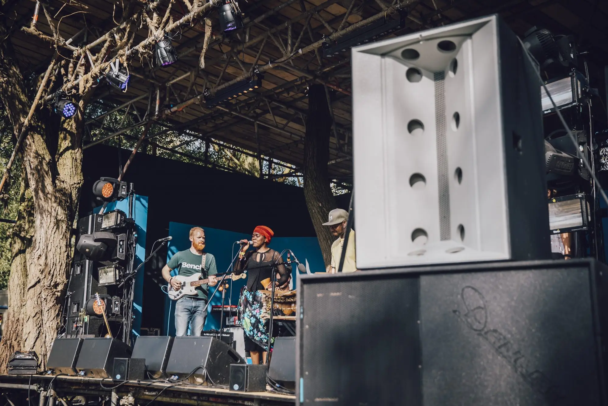Band performing on an outdoor stage with a Danley loudspeaker in the foreground