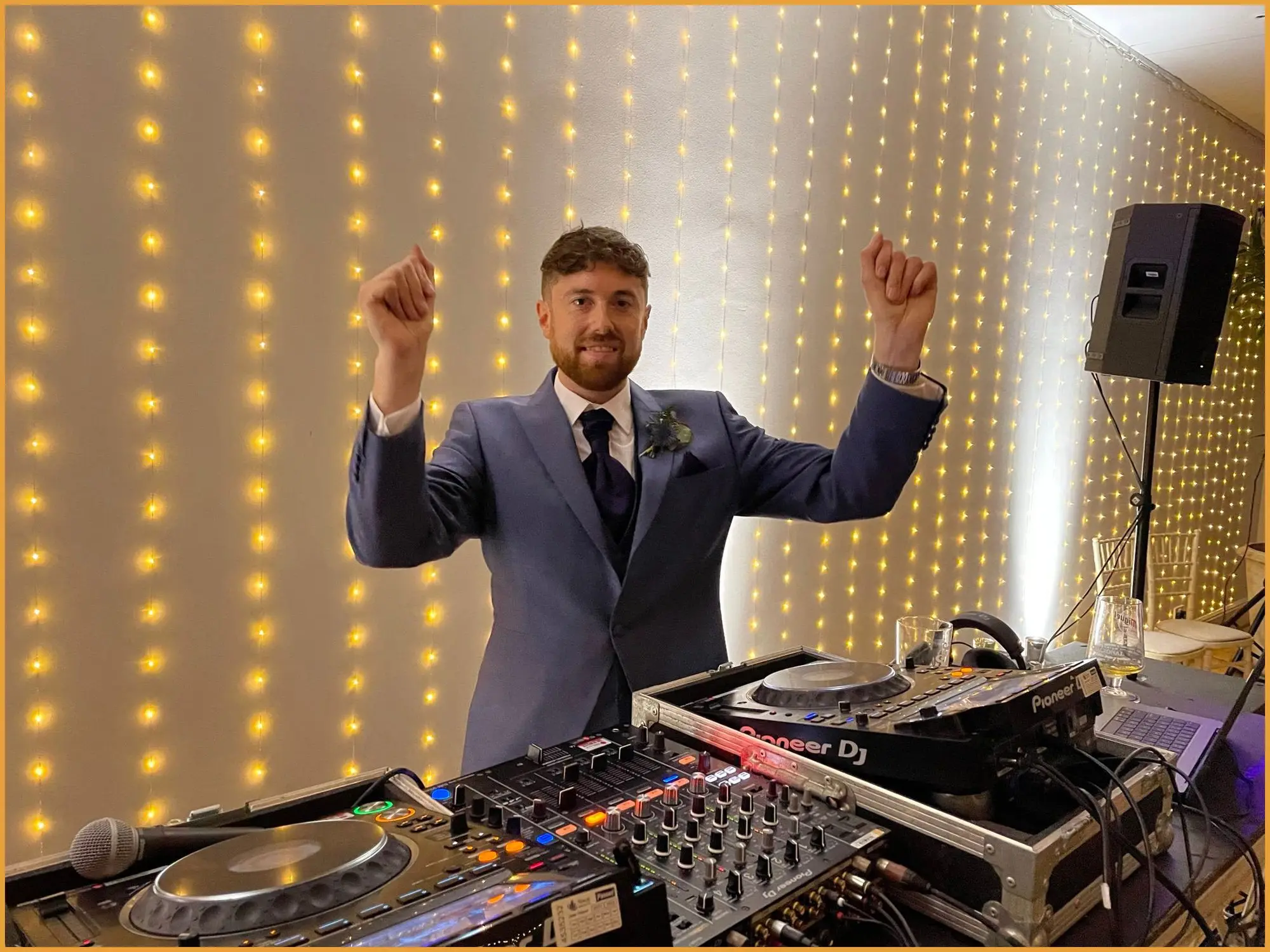 DJ performing behind a fairy-light backdrop at a private party