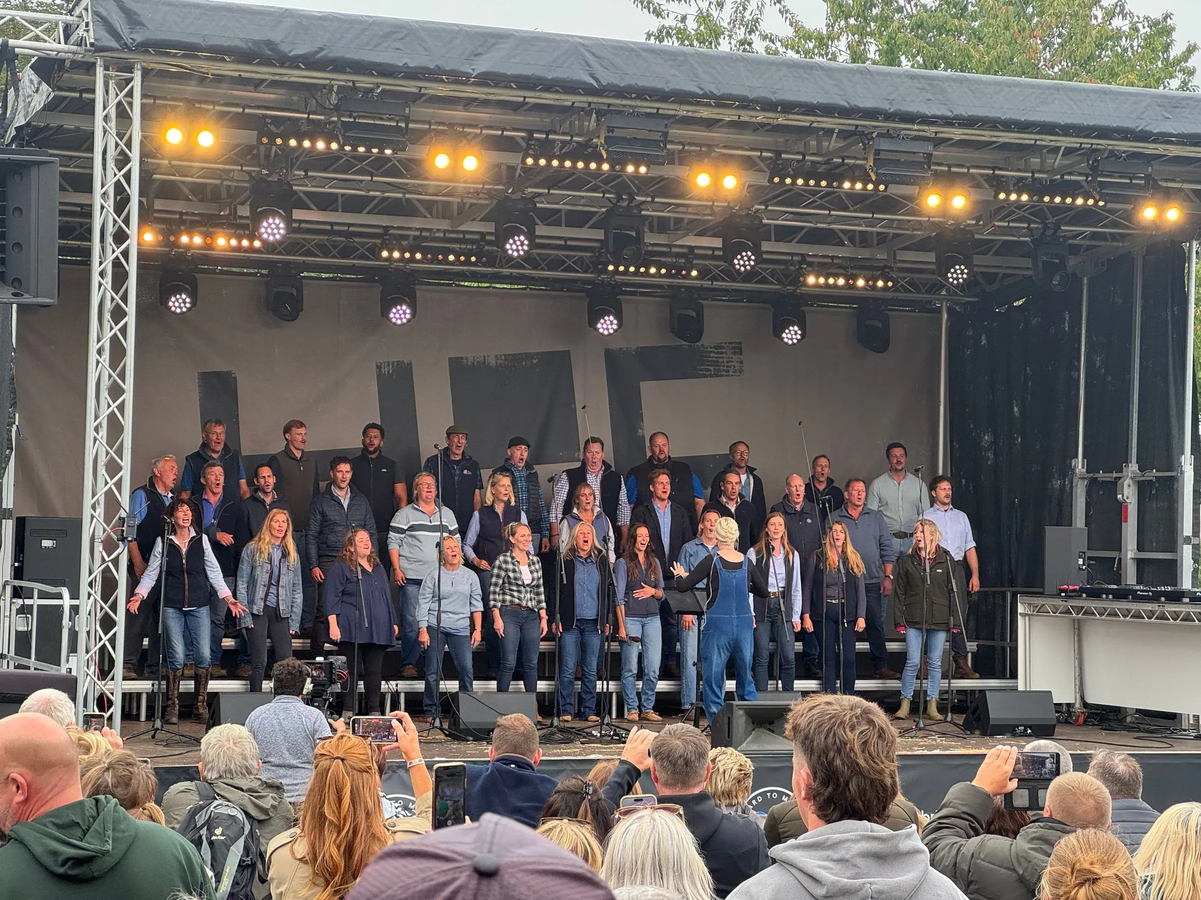 The Hawkstone Farmers Choir performing on Loud Hire's stage at The Farmer's Dog, with the audience in front