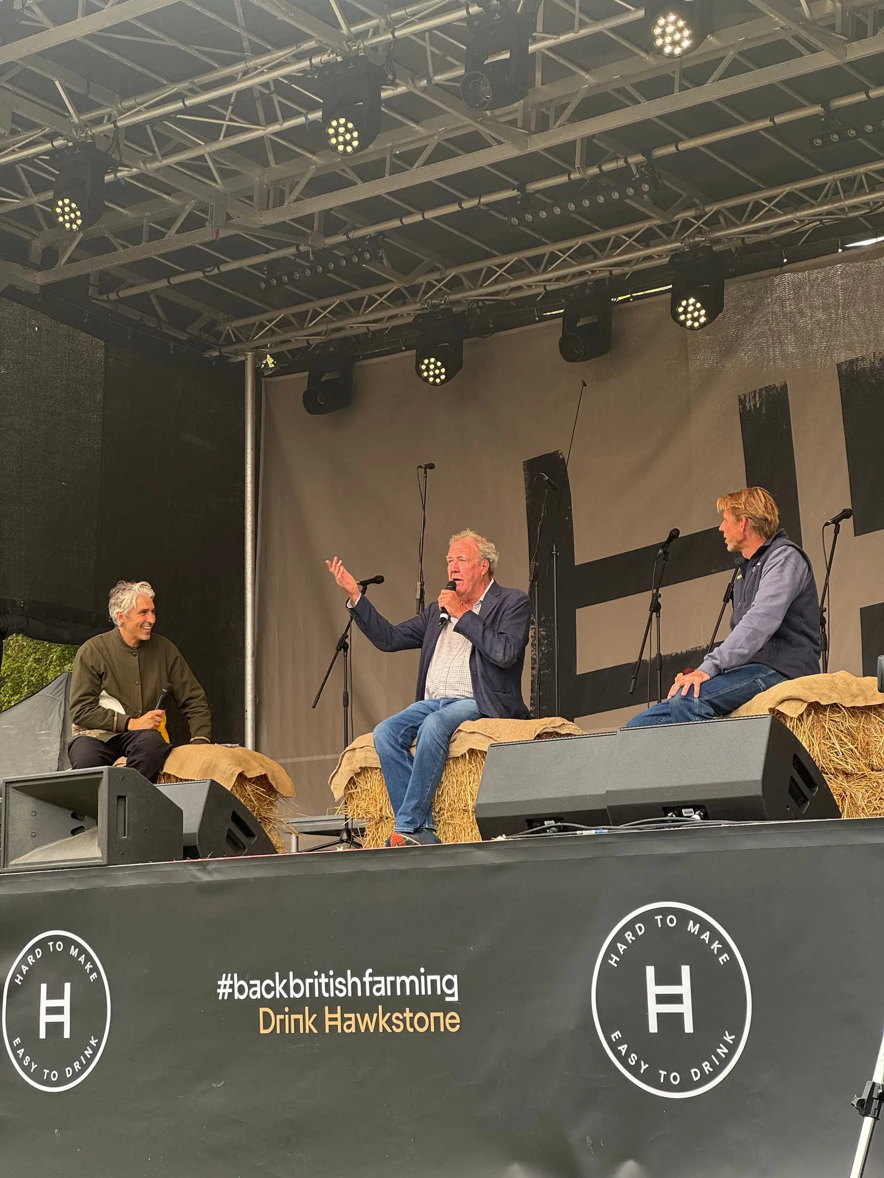 Speakers seated on straw bales during the farming discussion on stage