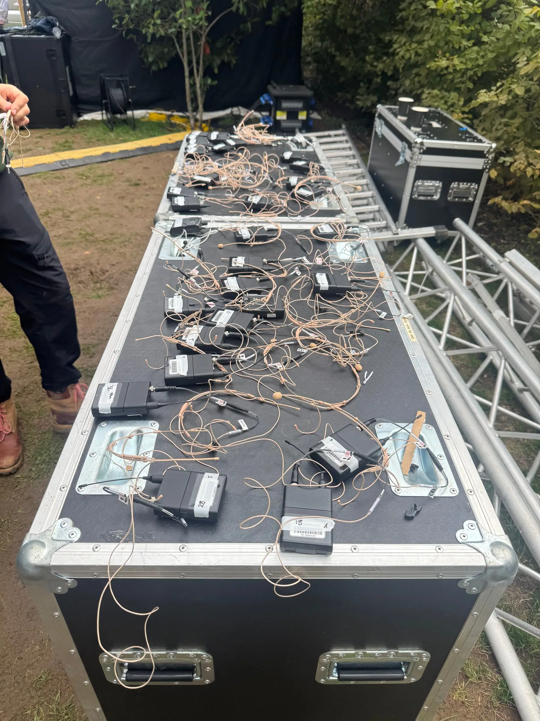 Headset microphones and wireless bodypacks laid out ready for the choir