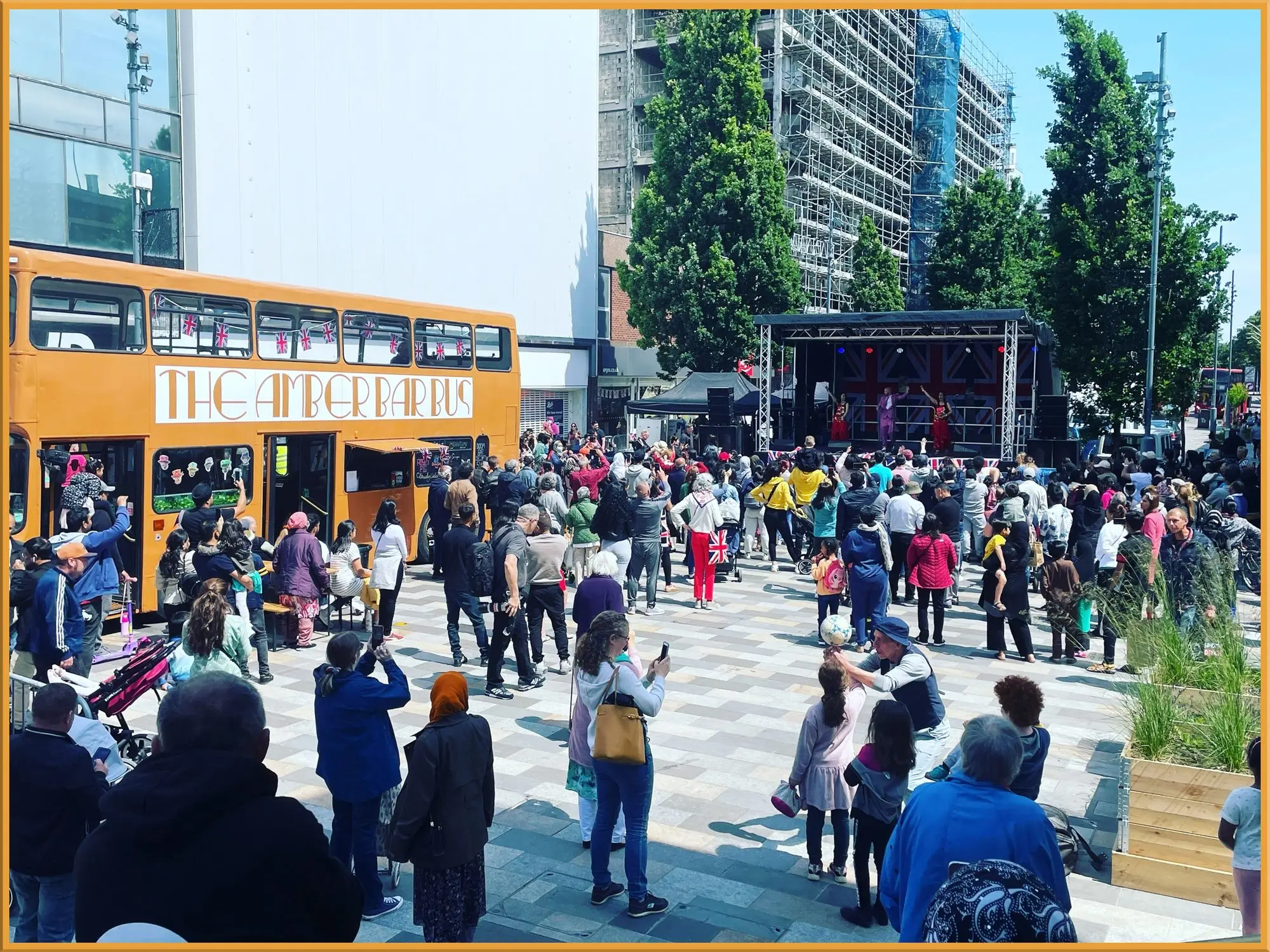 Busy pedestrianised high street with the stage in the distance