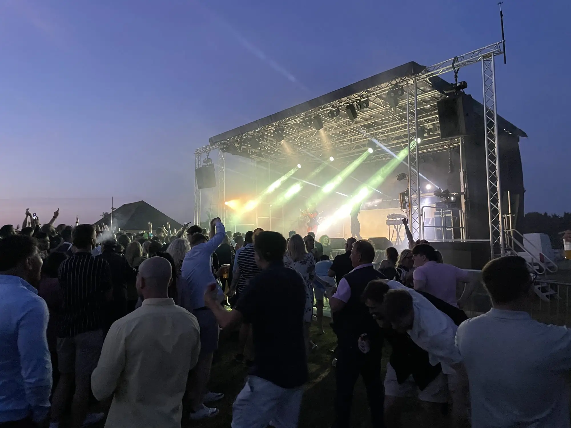 Crowd in front of a lit stage at night