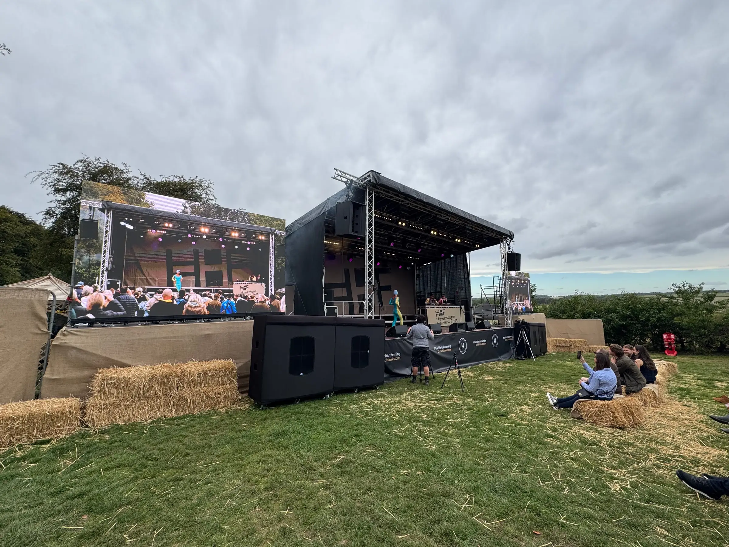 Wide view of the stage, loudspeakers and live video screens from the audience area