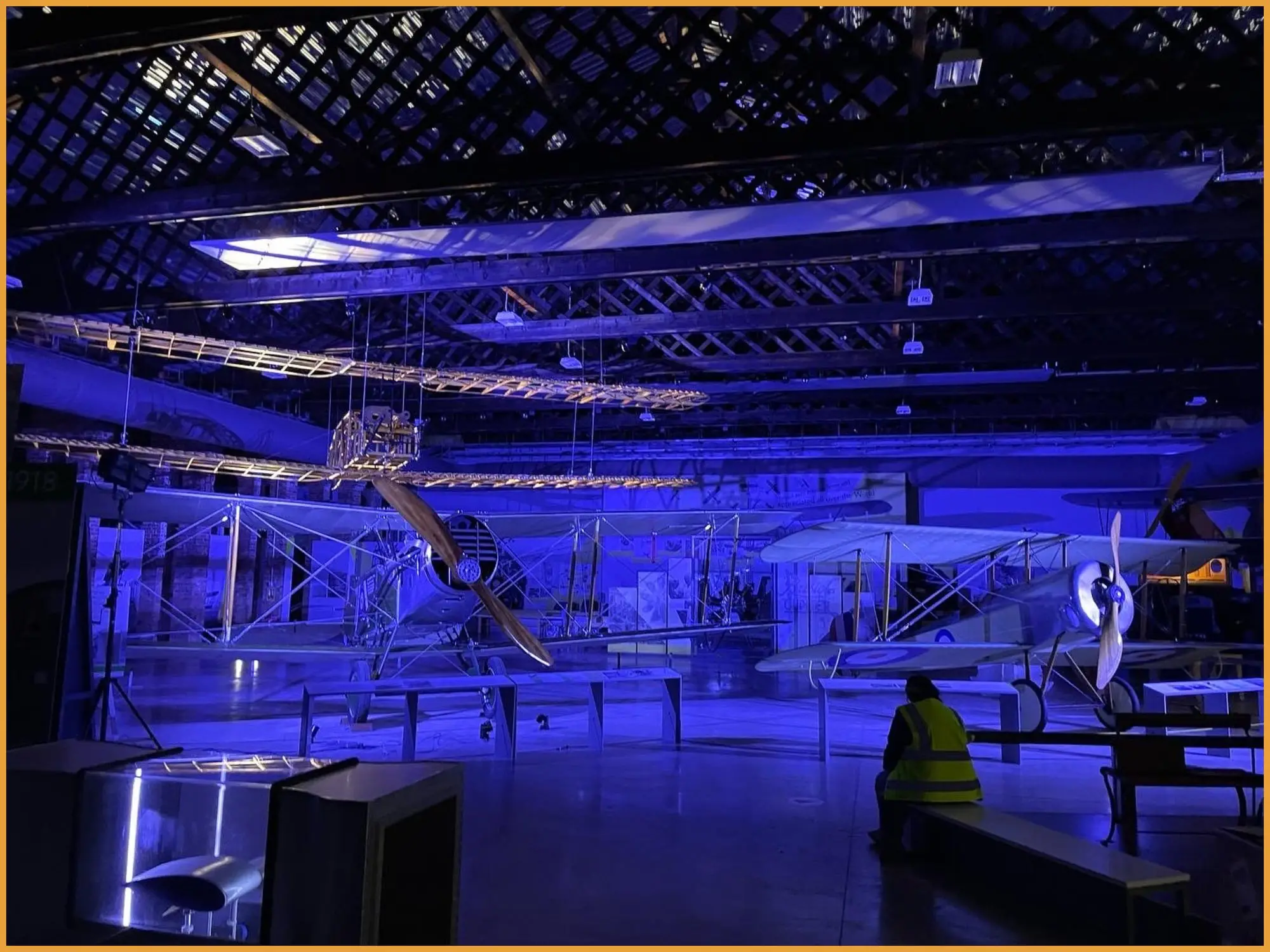 Vintage aircraft suspended in the hangar under blue lighting