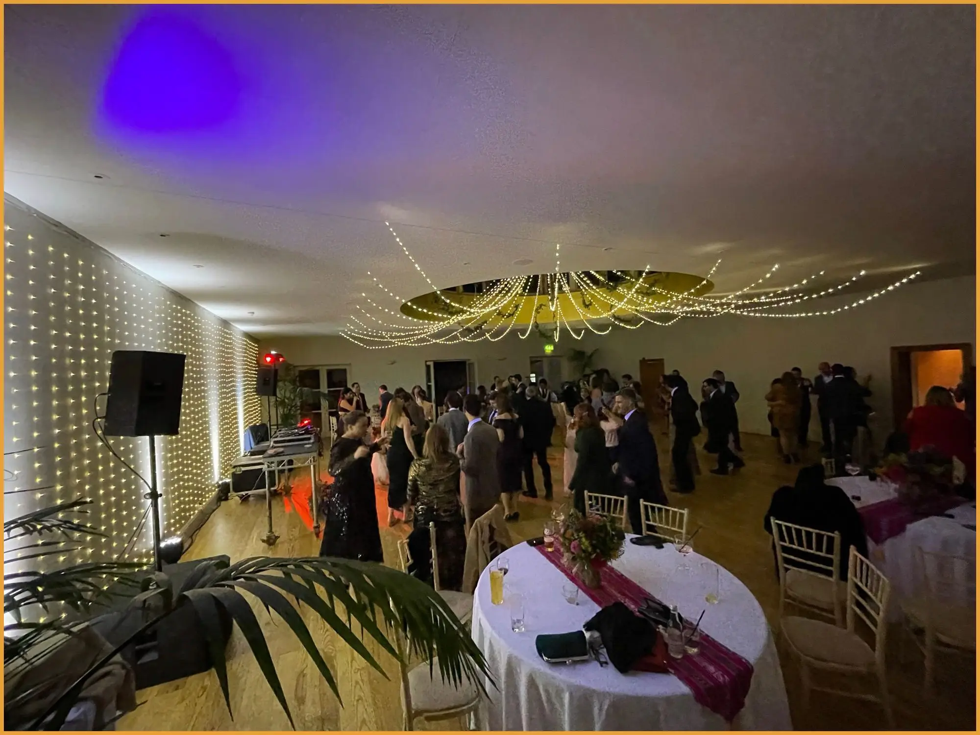 Guests dancing in a marquee lit with fairy lights