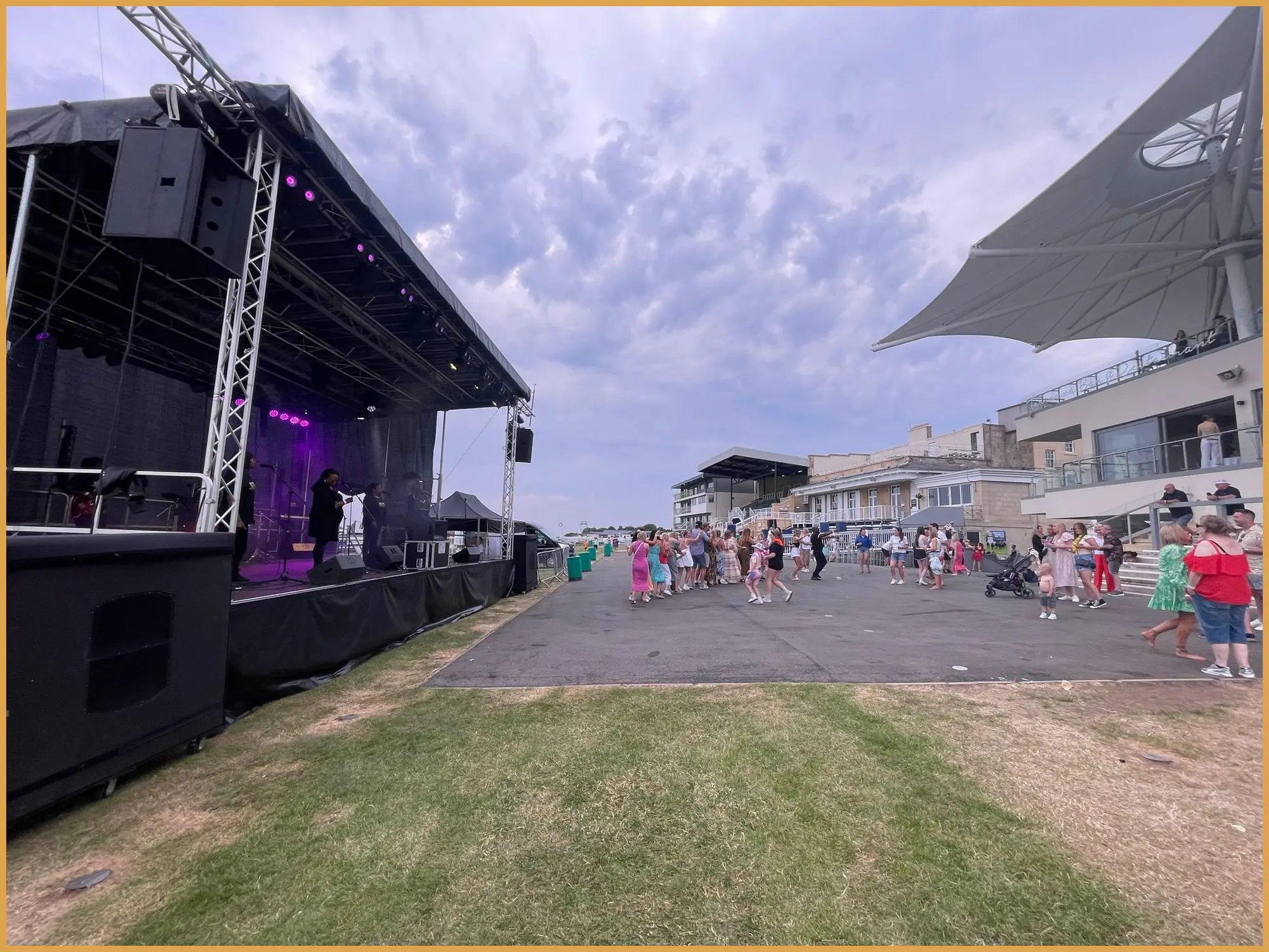 Side view of the outdoor stage with line array and crowd