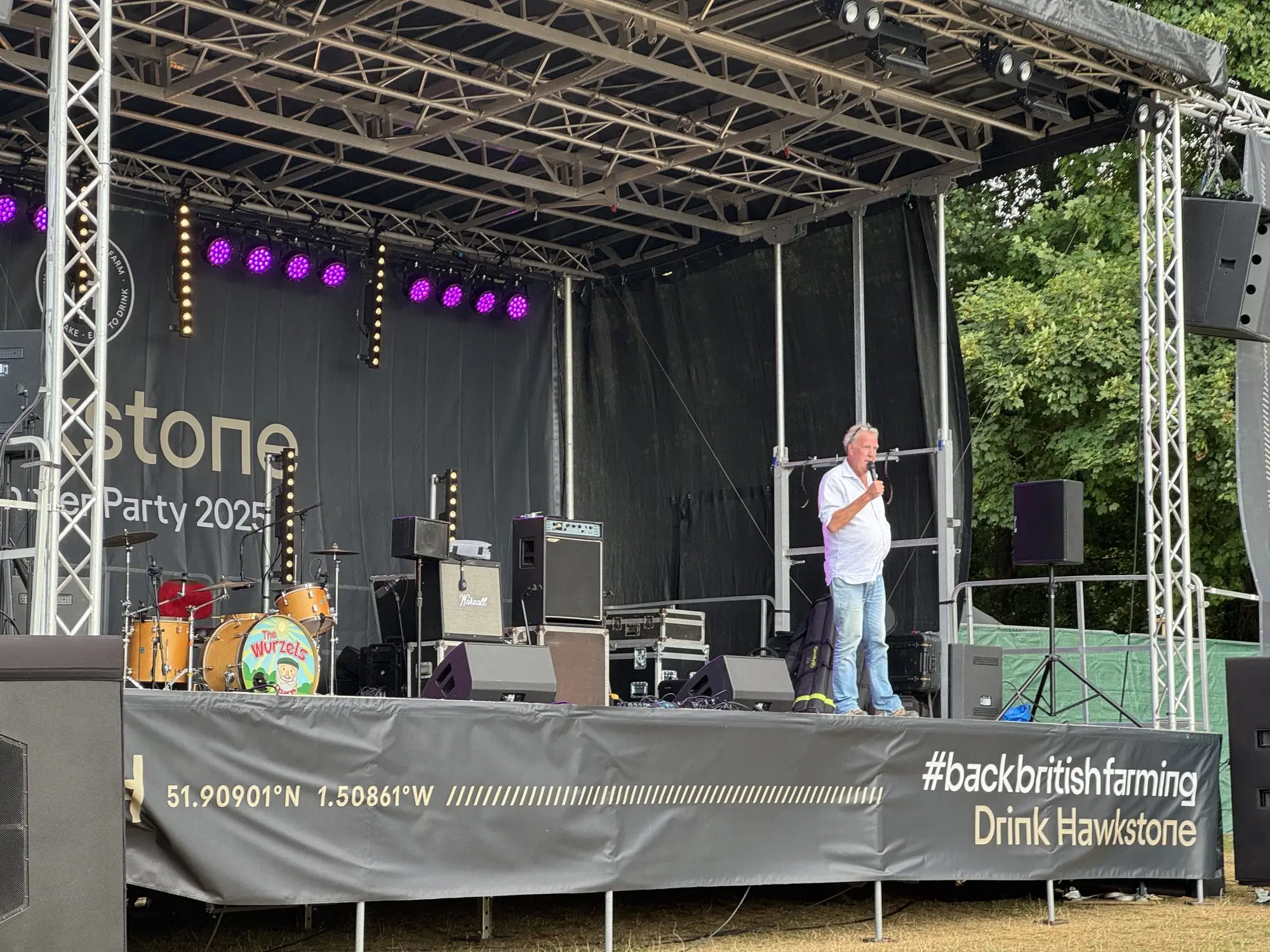 Presenter on a branded stage at a Hawkstone launch event